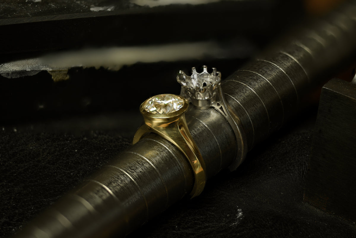 One diamond set ring and an old ring mount on a ring measuring stick
