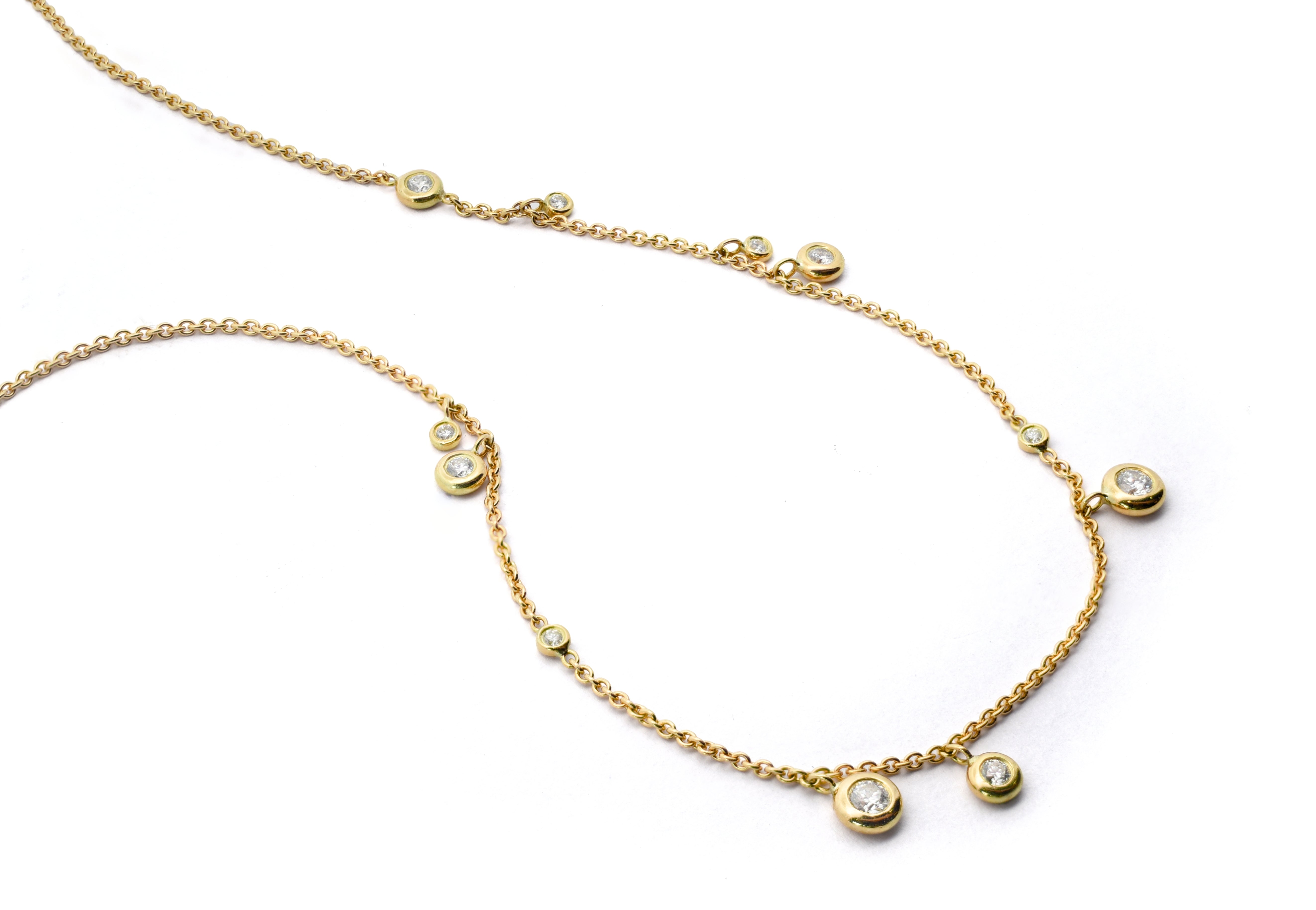 Gold necklace with small round pendants on a white background