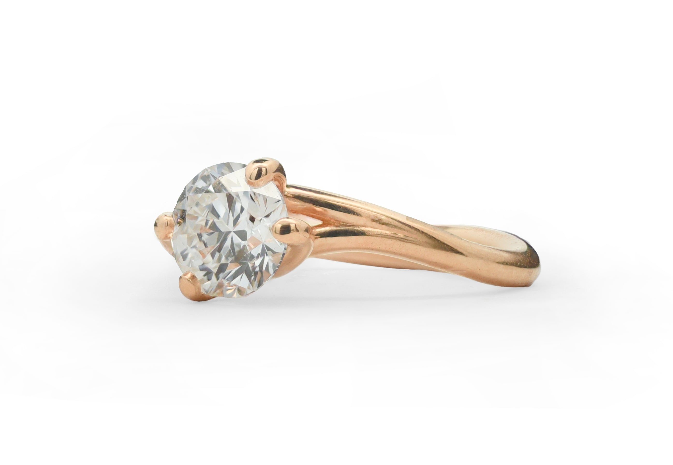 Rose gold Embrace ring with a diamond on a white background