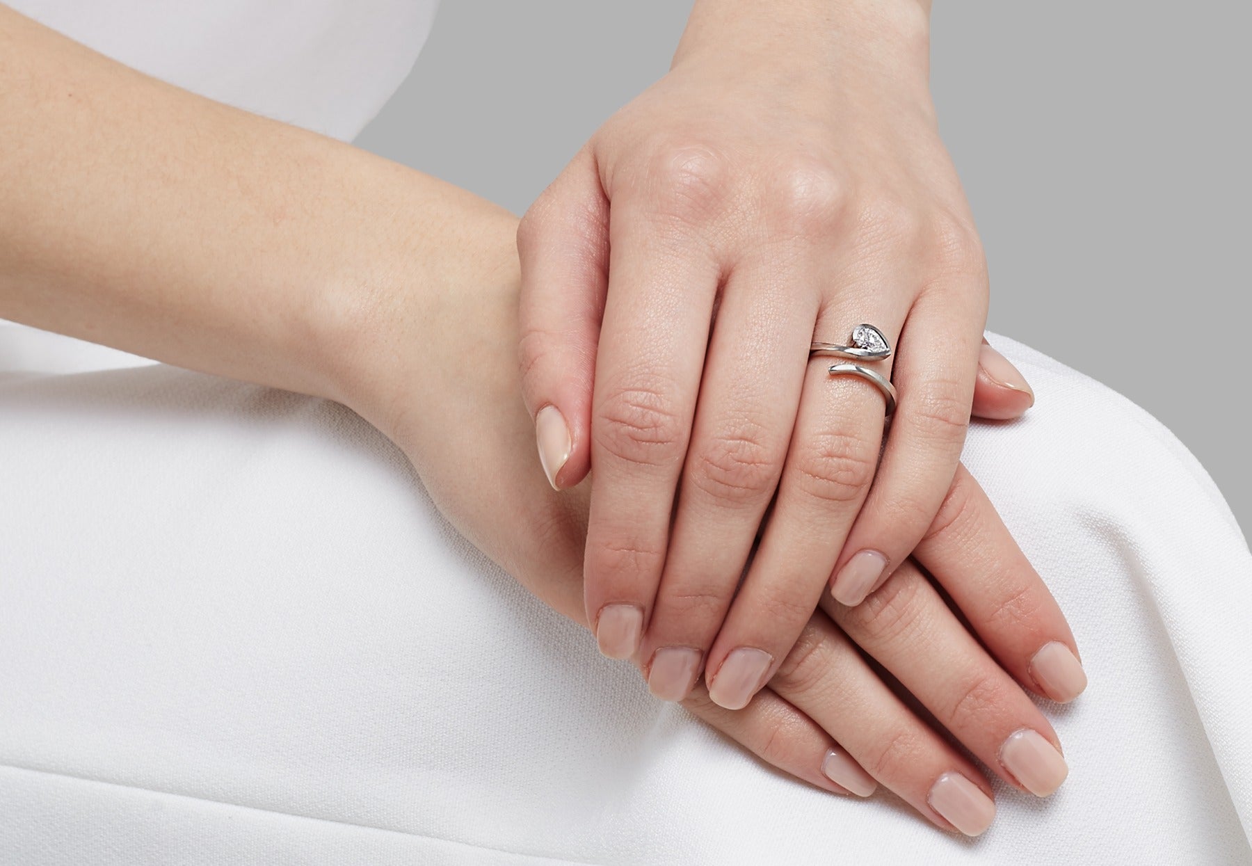 White pear shape diamond platinum twist engagement ring on hand