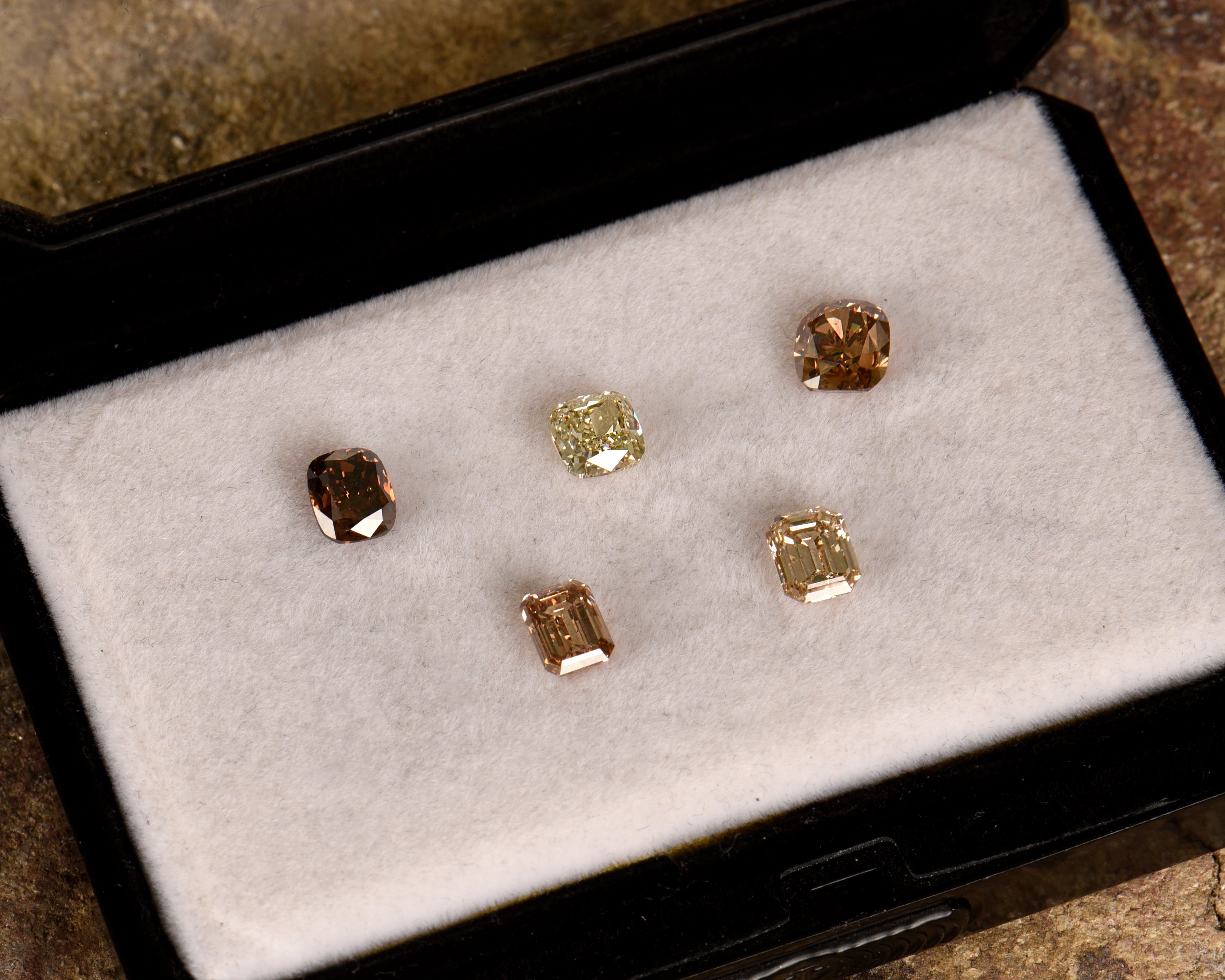 champagne and cognac diamonds in a display case on a textured surface