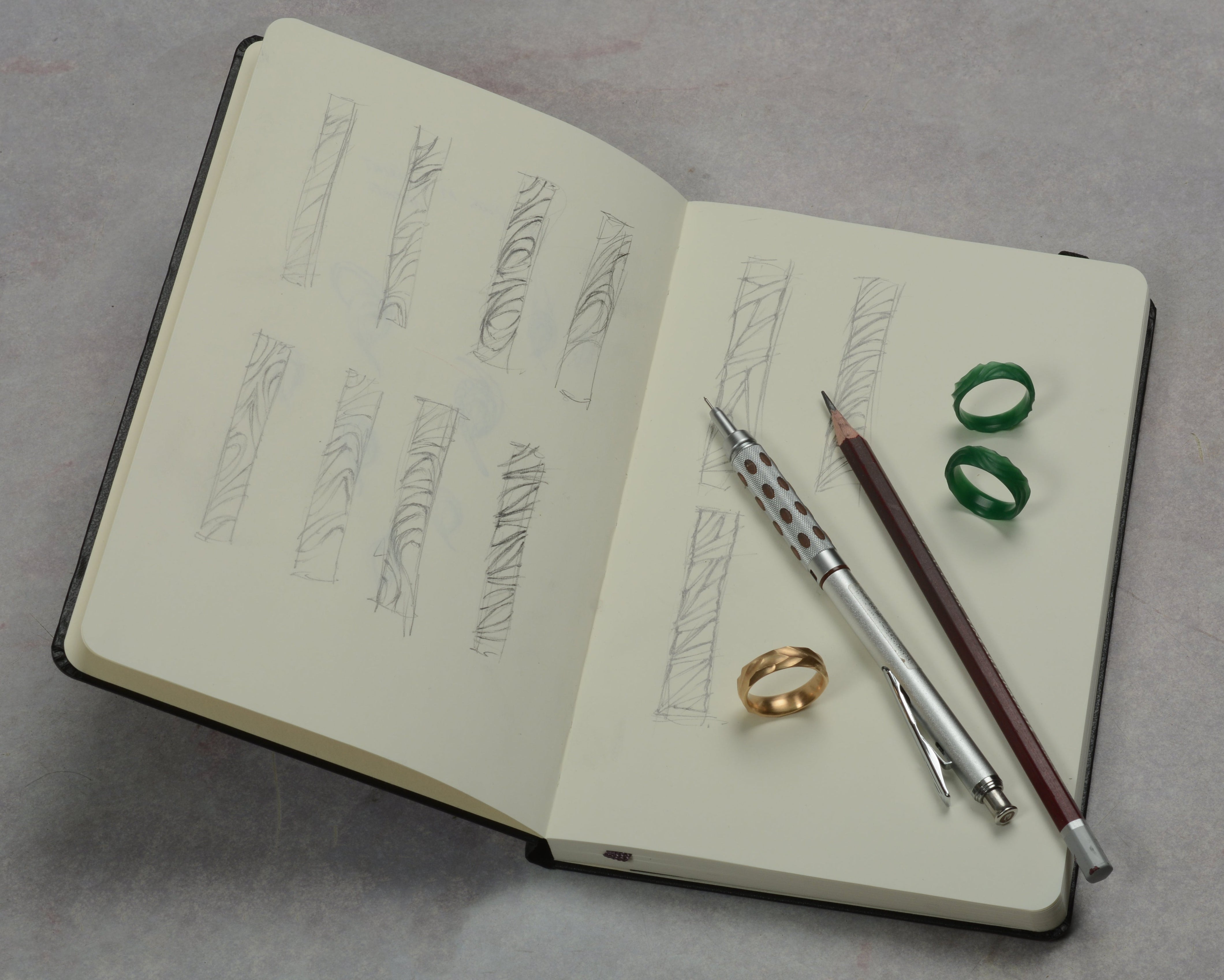 sketch book with textured ring designs and carved wax jewellery