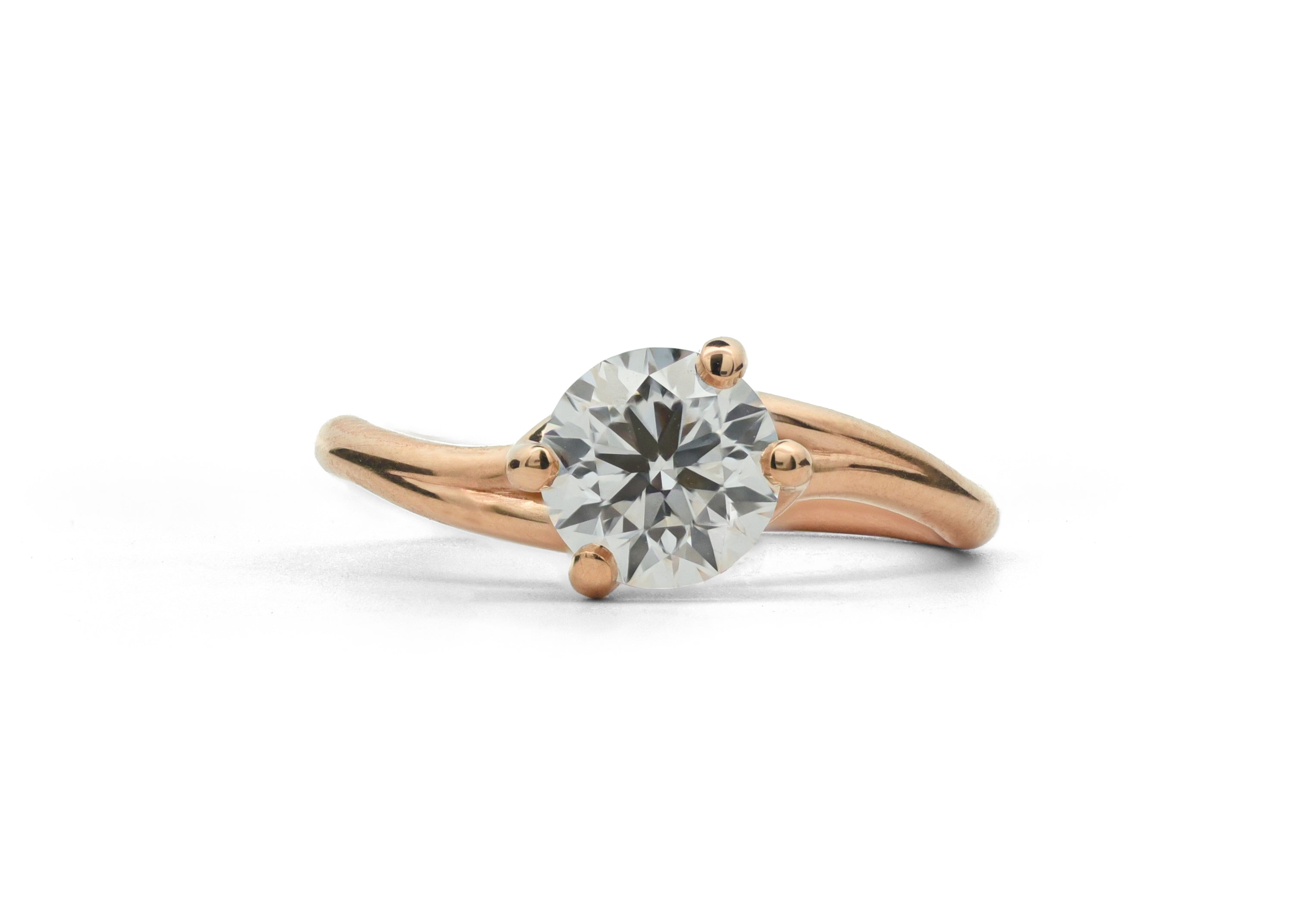 Rose gold ring with a diamond on a white background